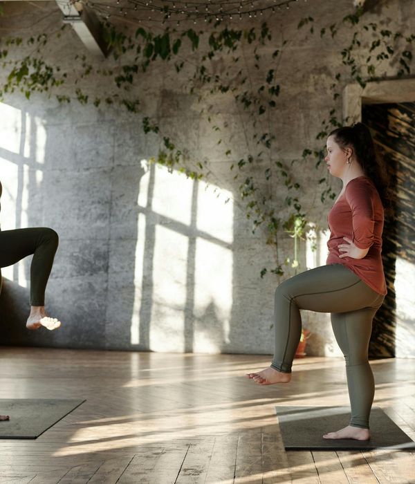 Woman feeling energized and stretching in a bright, sunlit room.